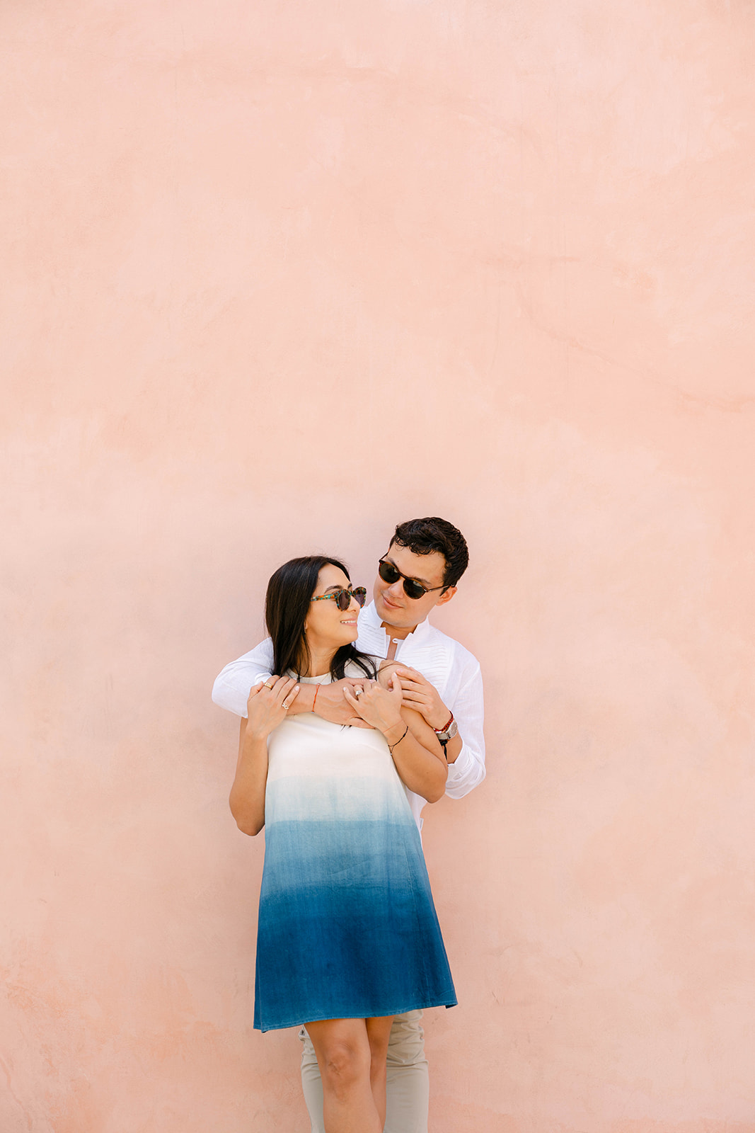 Ximena and Alexei embracing against a peach-colored wall